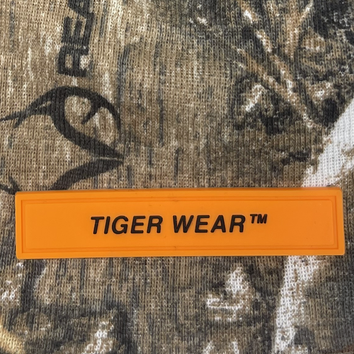 Close up of the orange PVC Tiger Wear label on the Woodland Pro Beanie