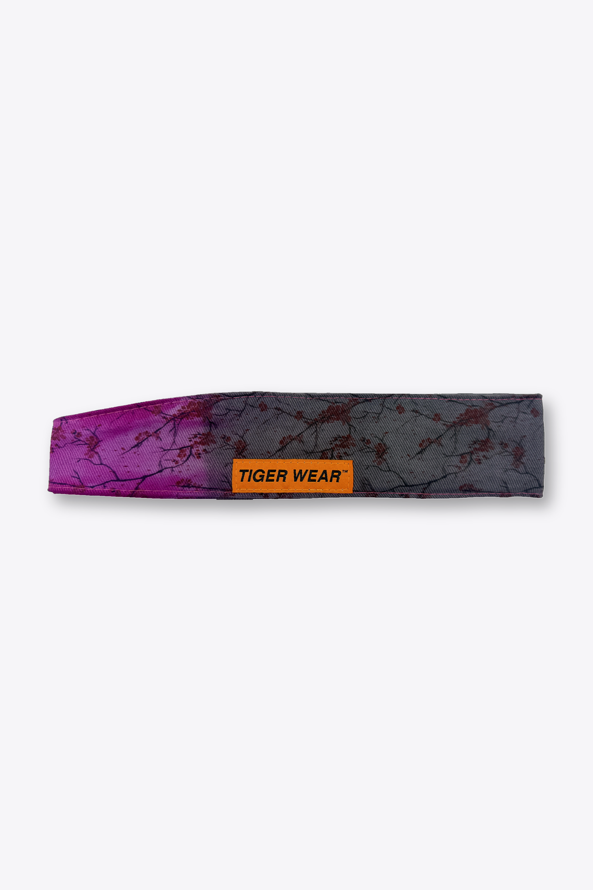Bloom at Dusk paintball headband by Tigerwear in magenta to charcoal blossom print, laid flat with orange woven label