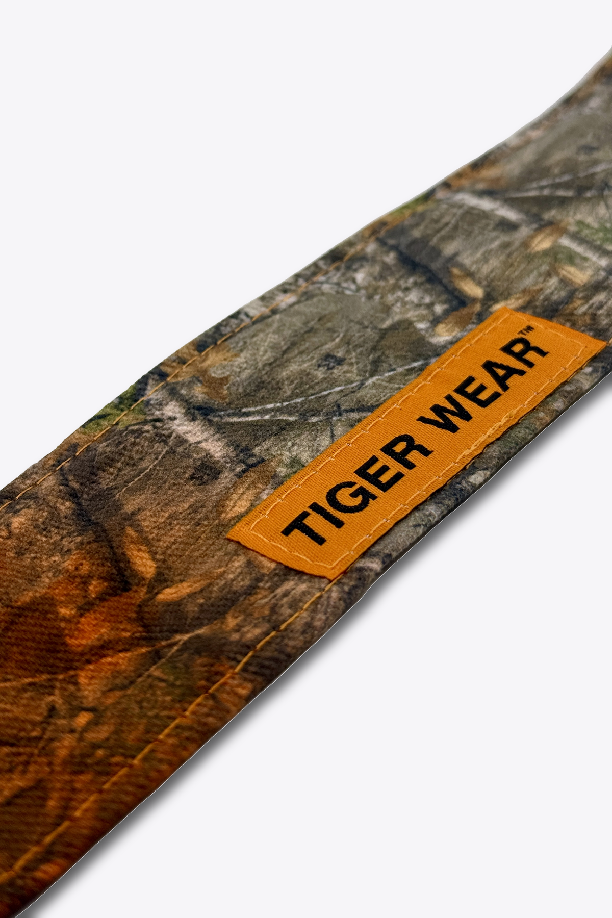 Close up of the orange woven Tiger Wear label on the First Light headband, orange fade timber camo