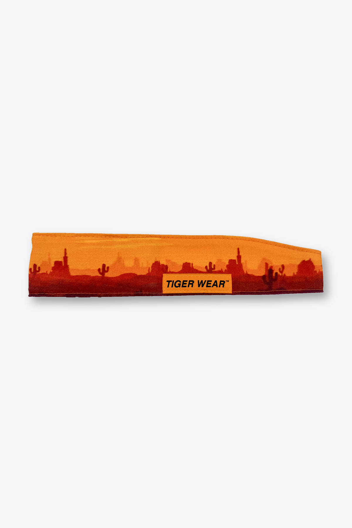 High Noon paintball headband by Tigerwear in orange desert sunset print, laid flat with orange woven label