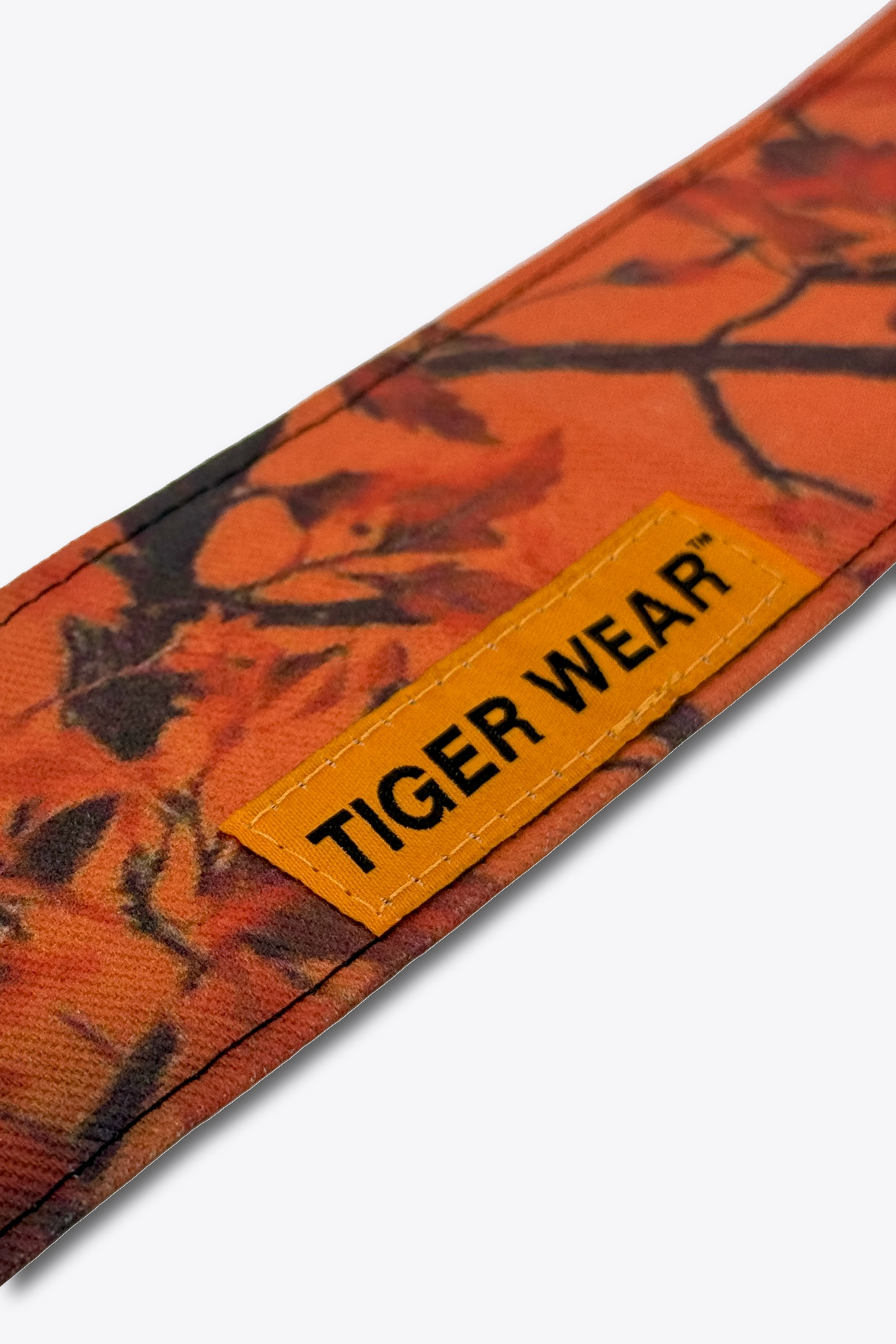Close up of the orange woven Tiger Wear label on the Opening Day headband, blaze orange leaf camo