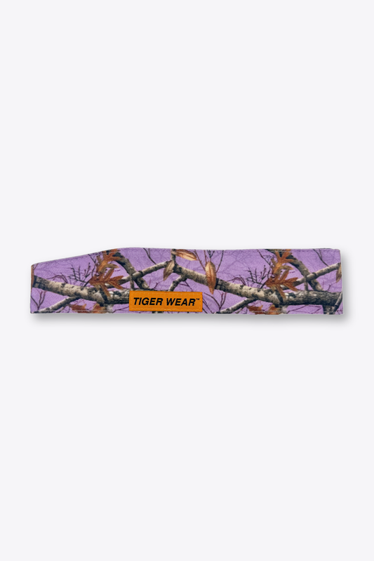 Violet Hour paintball headband by Tigerwear in lavender tree camo, laid flat with orange woven label